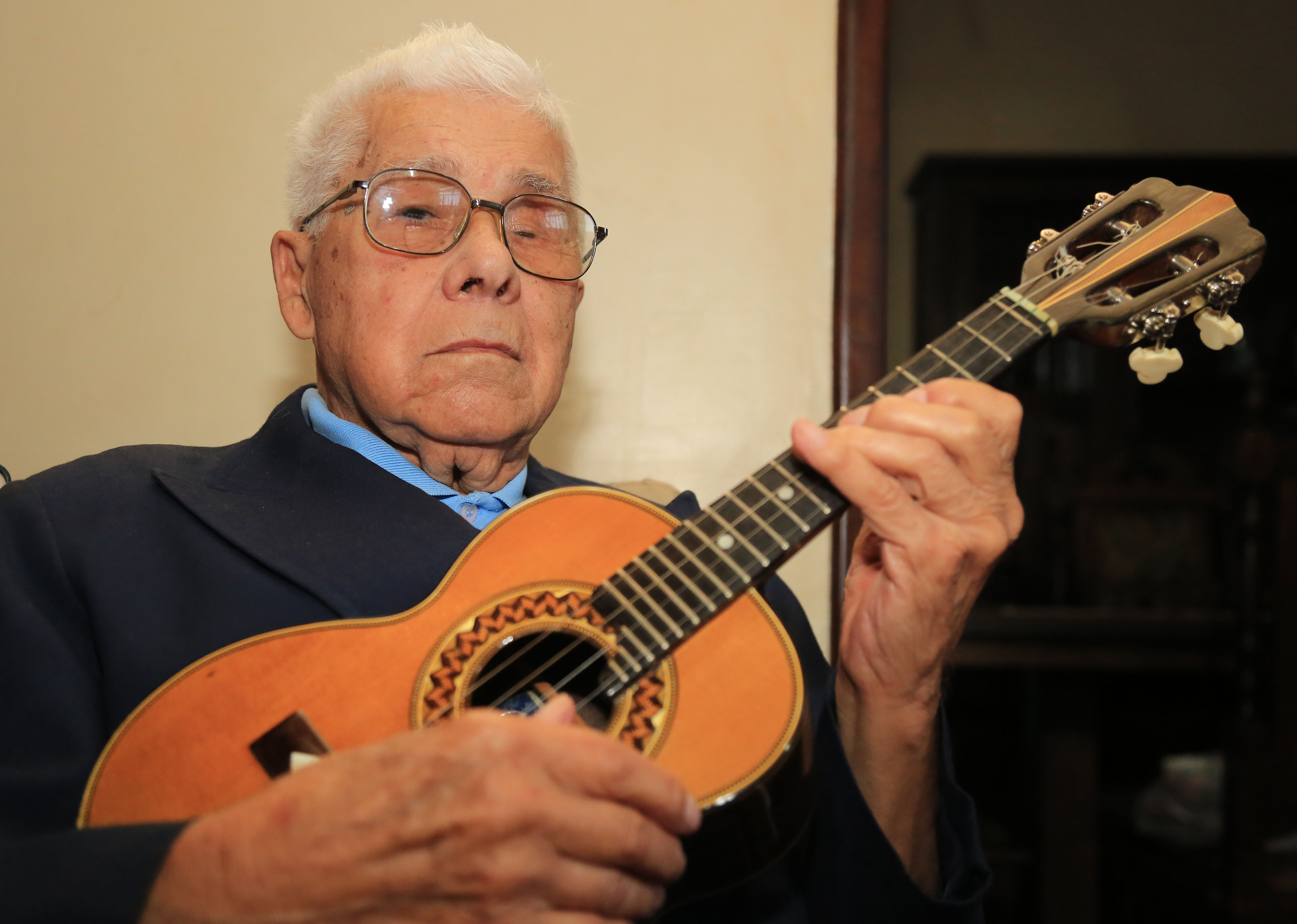 Moacyr hoje, aos 90 anos, com o cavaquinho que ganhou de Canhoto. À direita, o moço “com bigode de salafrário” em turnê no Rio de Janeiro, na década de 1950. | Pedro Serapio/Gazeta do Povo