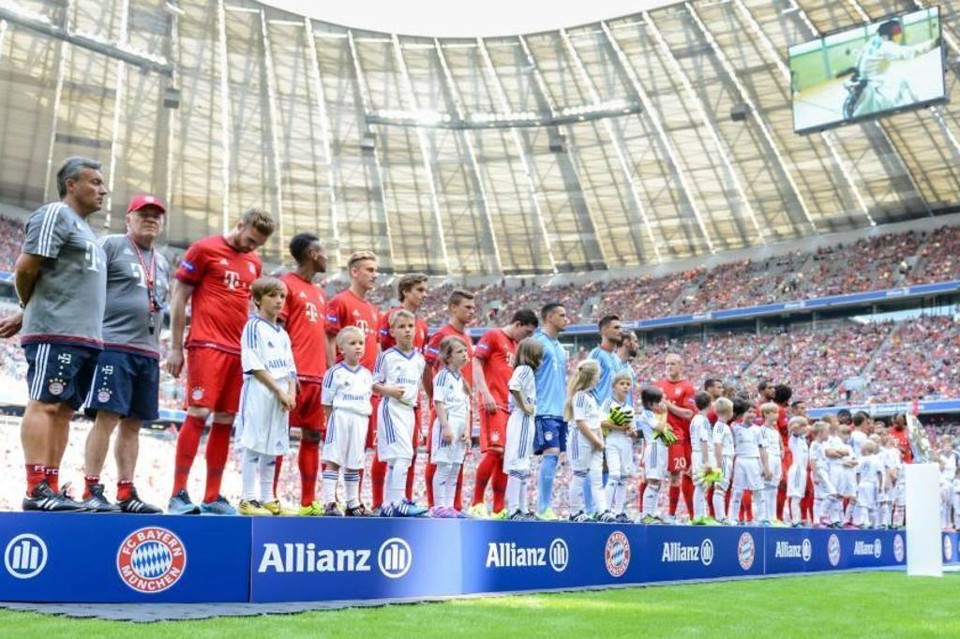 Jogadores do Bayern de Munique perfilados e acompanhados de crianças dentro do Allianz Arena: clube vem se destacando em ações sociais. | Reprodução/Facebook