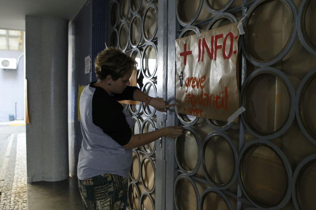 Estudante cola cartaz na porta do prédio da reitoria da UFPR | /