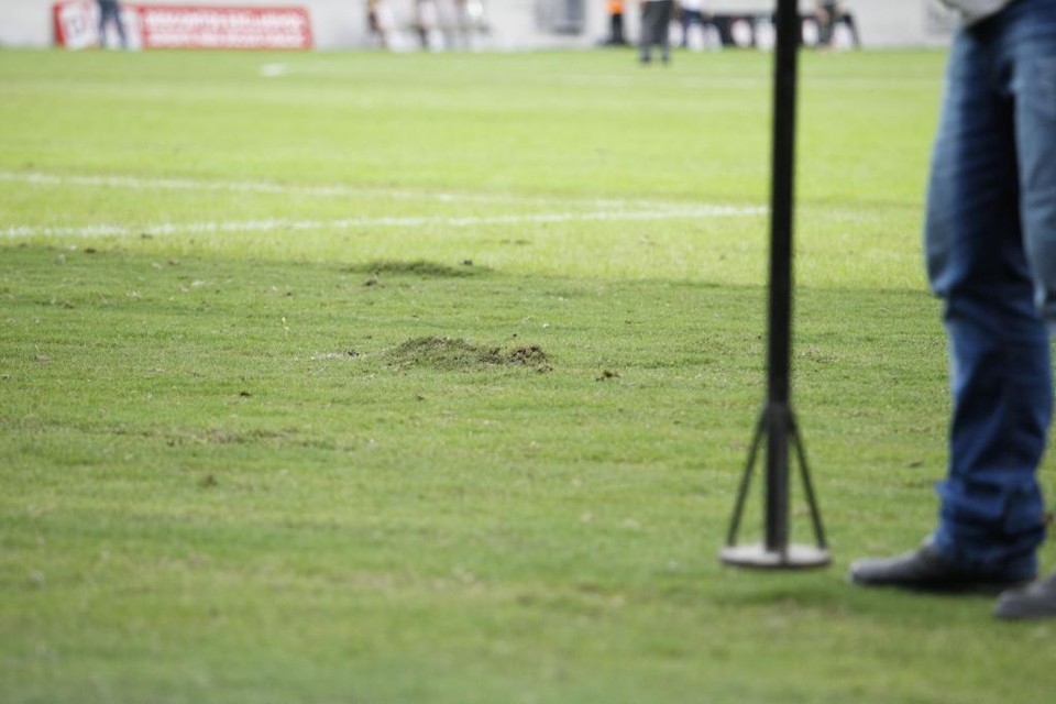 Funcionoário do Atlético tenta ajustar o gramado da Arena durante a partida com a Ponte Preta no último domingo. | Daniel Castellano/Gazeta do Povo