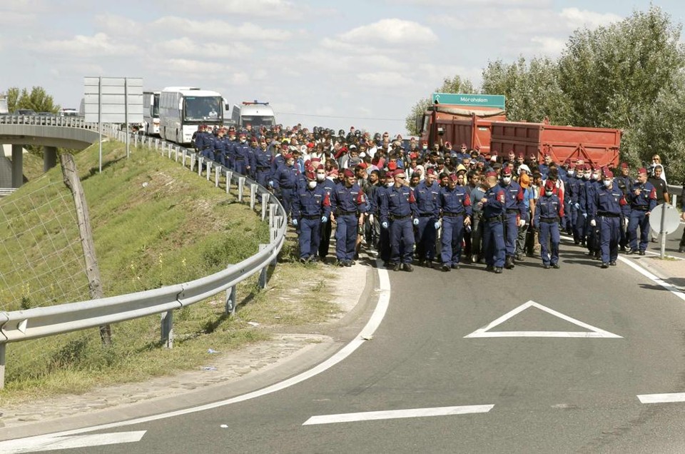 Policiais húngaros escoltam imigrantes após fechamento de rodovia pelo país. | Marko Djurica/
Reuters