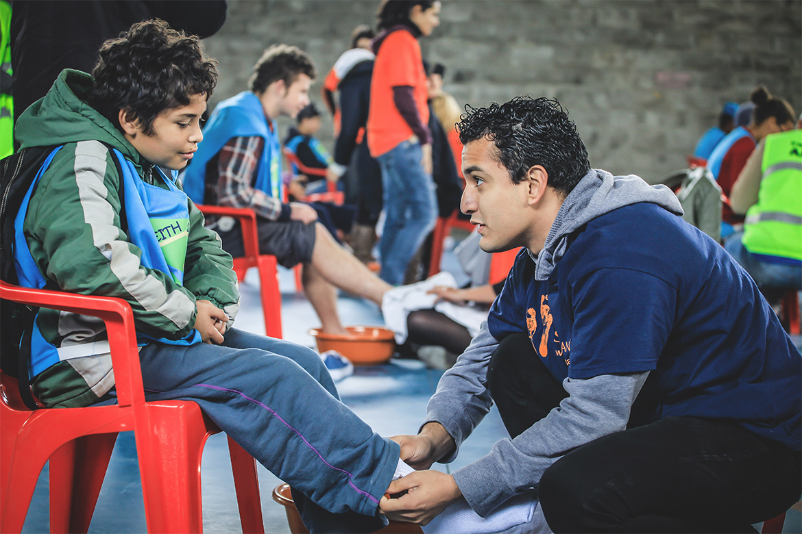 Além de doar calçados, voluntários lavam os pés das crianças e as encorajam a buscar seus sonhos. | RPDOIS Fotografia