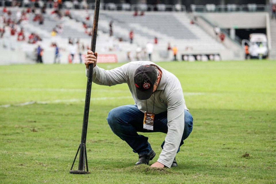 Funcionário do Atlético tenta ajustar o gramado da Arena no jogo com a Ponte Preta. | Daniel Castellano / Gazeta do Povo/