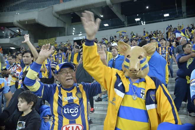 Torcedor do Luqueño com máscara de porco, o mascote da equipe. | Foto: Albari Rosa/Gazeta do Povo