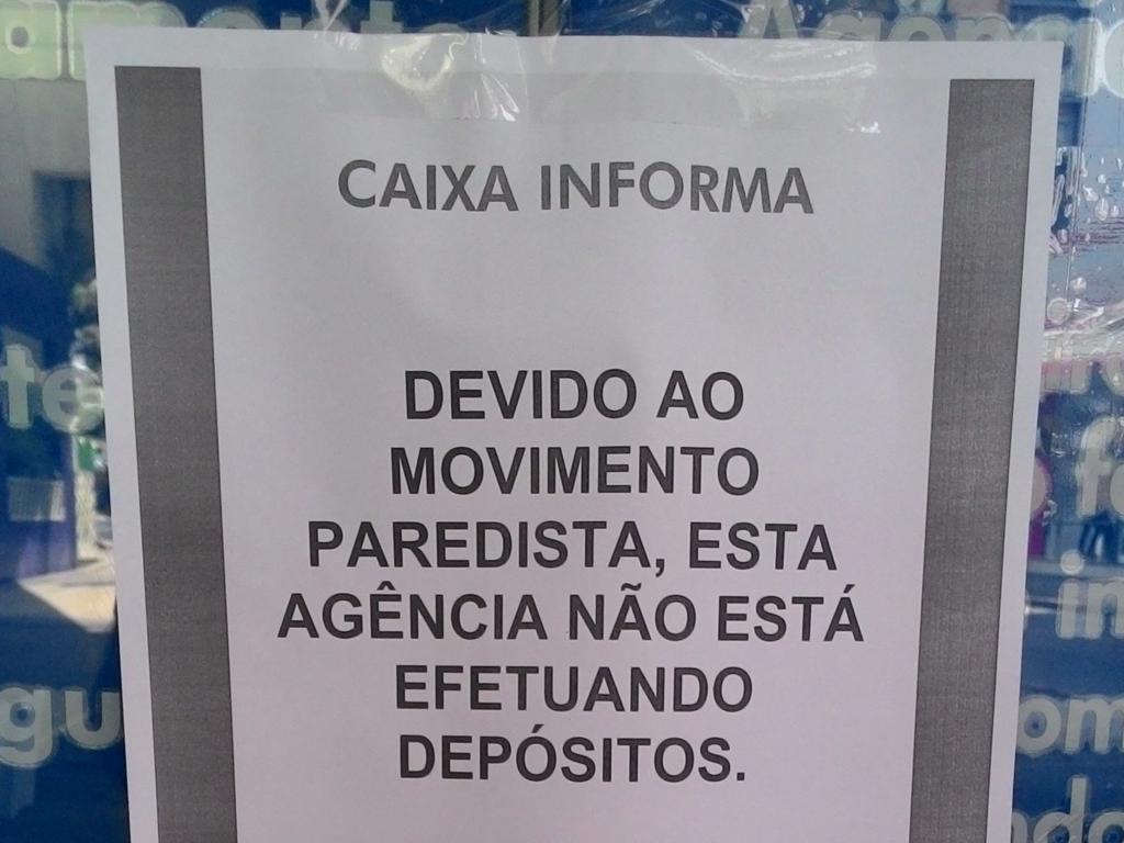 Aviso colado na porta de uma agência do Centro de Curitiba. | Fábio Cherubini/Gazeta do Povo