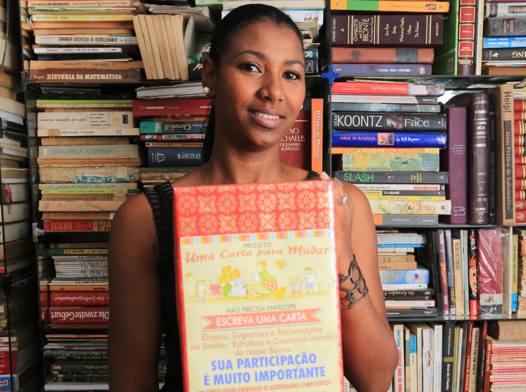 Luciana Cortes, a biblioteca caseira que divide com o marido Fernando e uma das famosas caixas que atiçaram a participação popular no Rio Bonito. | Ivonaldo Alexandre / Gazeta do Povo