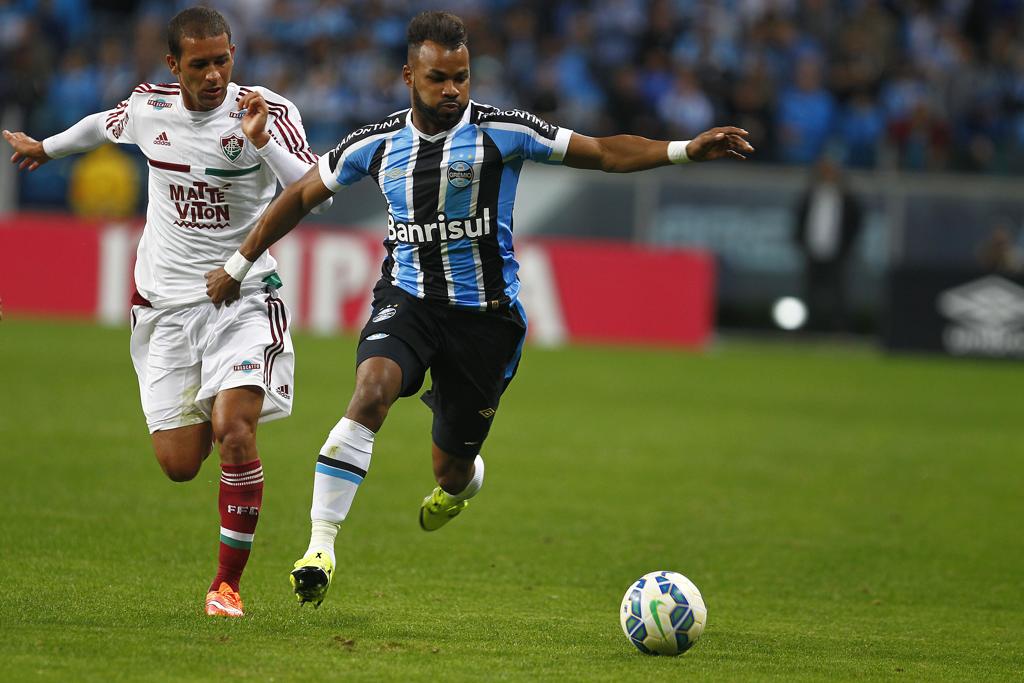 O volante Pierre, do Fluminense, disputa a bola com o atacante gremista Fernandinho no empate por 1 a 1 que beneficiou os cariocas. | Lucas Uebel/Lucas Uebel/Gremio FBPA
