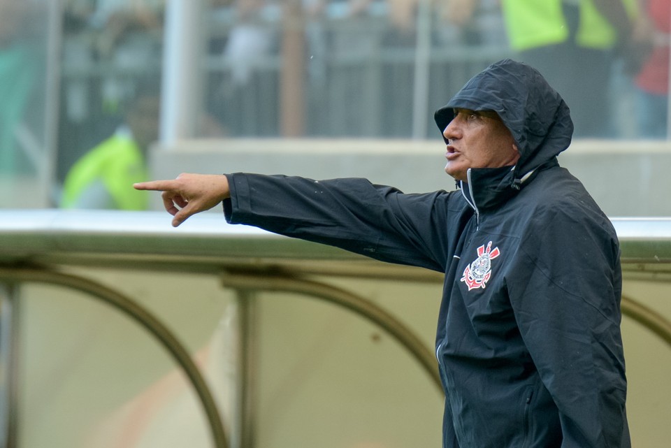 Tite teve de recorrer a um agasalho com capuz para se proteger das cusparadas da torcida do Galo. | André Yanckous/Folhapress