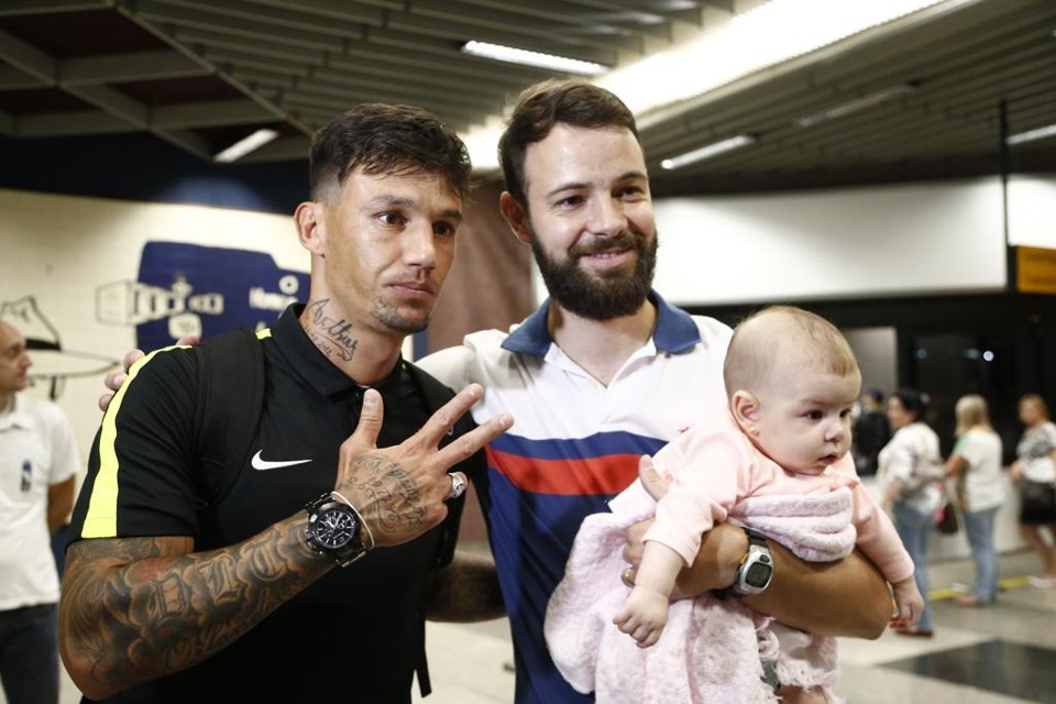 O volante João Paulo posa para foto com torcedor do Coritiba no desembarque depois da vitória sobre o Goiás: “o Coxa não vai cair”. | Hugo Harada/Gazeta do Povo