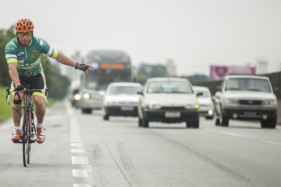 Ciclista Denis Kuchler precisa dividir espaço com carros, ônibus e caminhões na rodovia. | Marcelo Andrade/Gazeta do Povo