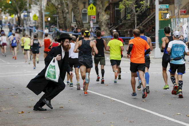 Pedestre passa pelos corredores na Maratona de Nova York. | SHANNON STAPLETON/REUTERS