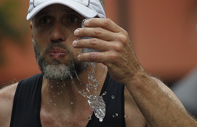 Participante da prova se refresca. | Jonathan Campos/Gazeta do Povo