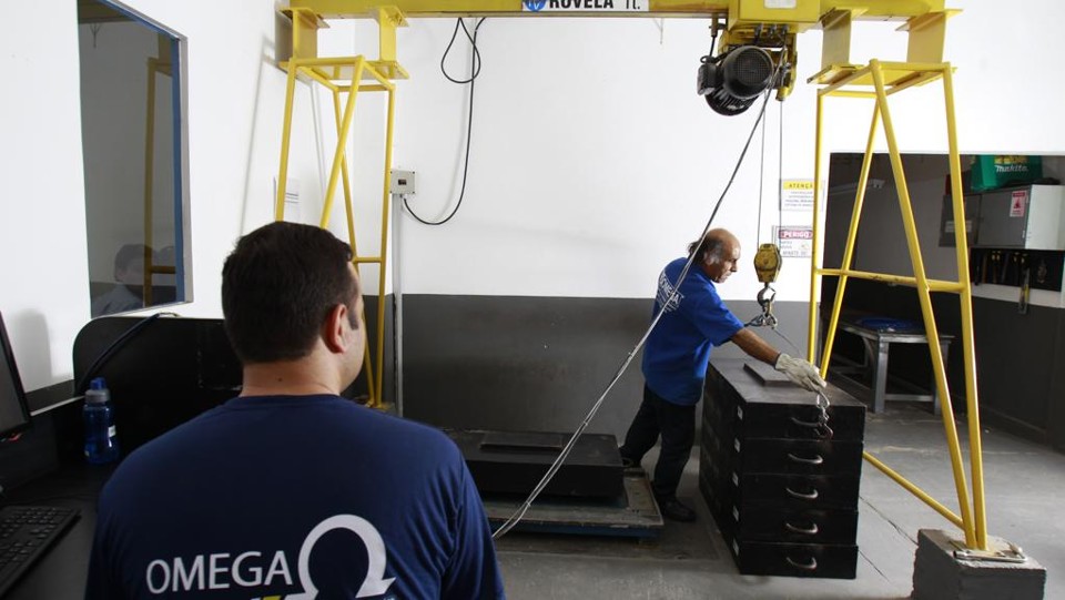 Funcionários da área de manutenção fazendo a calibragem de uma balança: receita de serviços ganhou importância. |