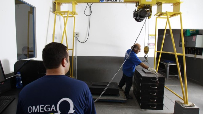 Funcionários da área de manutenção fazendo a calibragem de uma balança: receita de serviços ganhou importância. |