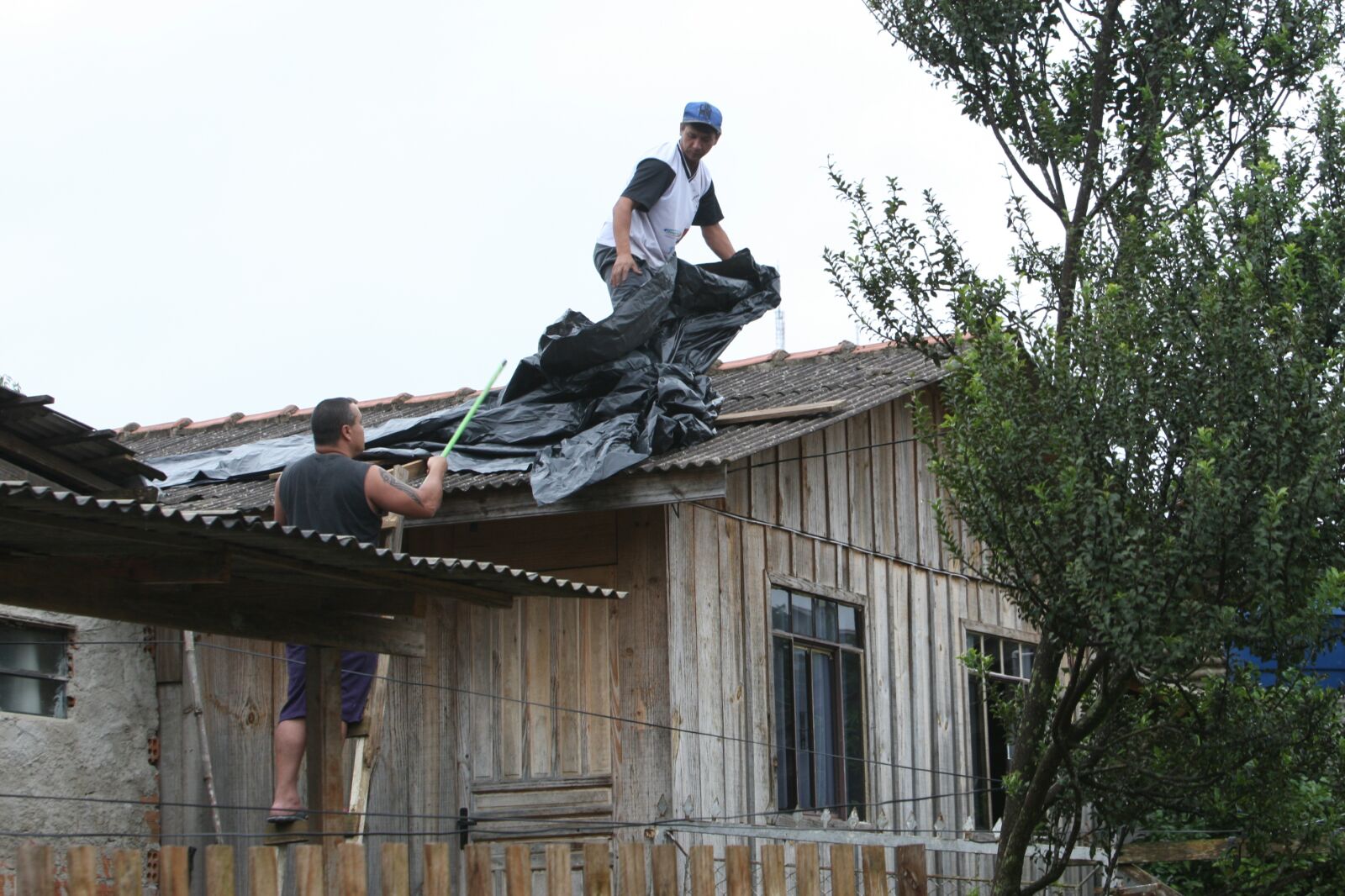 Moradores do Pilarzinho, em Curitiba, cobriam telhados com lona, na manhã desta segunda-feira (23) | Aniele Nascimento/Gazeta do Povo