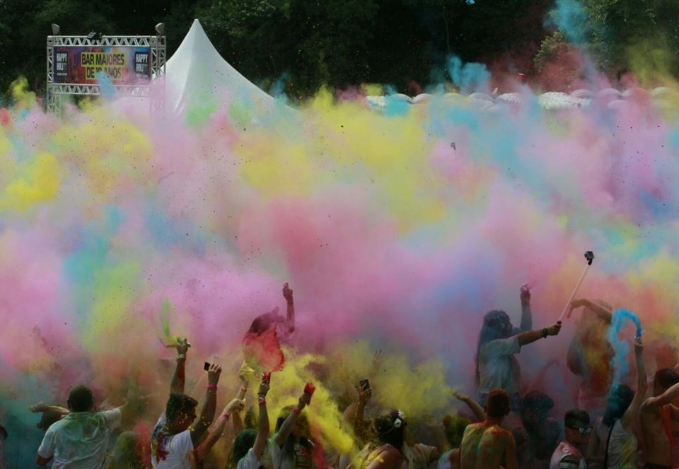 Festa reúne pessoas vestidas de branco para pintarem umas às outras com pó colorido. | Aniele Nascimento/Gazeta do Povo