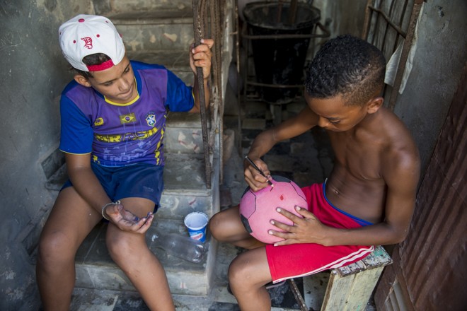 Eric e Yassiel, ambos com 11 anos, desenham gomos em uma bola de borracha para “ficar parecida com uma bola oficial” | Henry Milléo