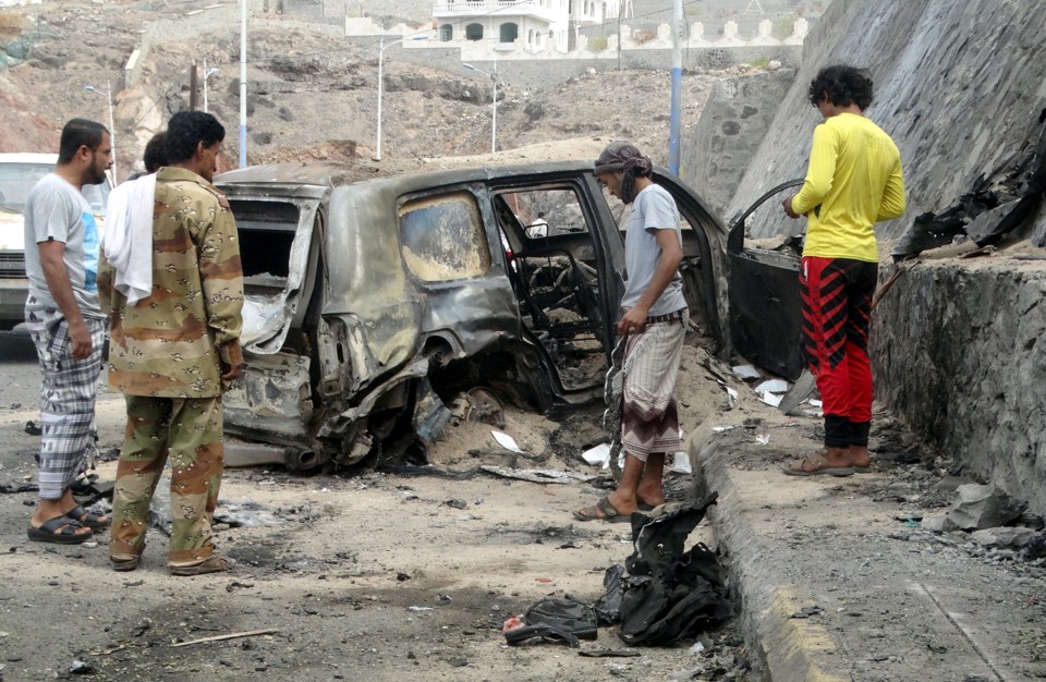 Pessoas observam os destroços do carro-bomba que matou o governador Jaafar Mohammed Saadda. | NASSER AWAD/Reuters