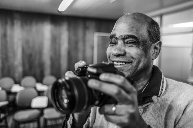 Oficina de fotografia para deficientes visuais na seção braile da Biblioteca Pública do Paraná ministrada pela fotógrafa Juliana Stein. Na foto, um dos funcionários da Biblioteca Pública do Paraná, Anastacio. | Daniel Castellano/Gazeta do Povo