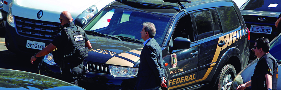 Alberto Yousseff (ao centro), escoltado por policiais federais: doleiro já havia sido investigado no escândalo do Caso Banestado, em 2002. | Antônio More/Gazeta do Povo