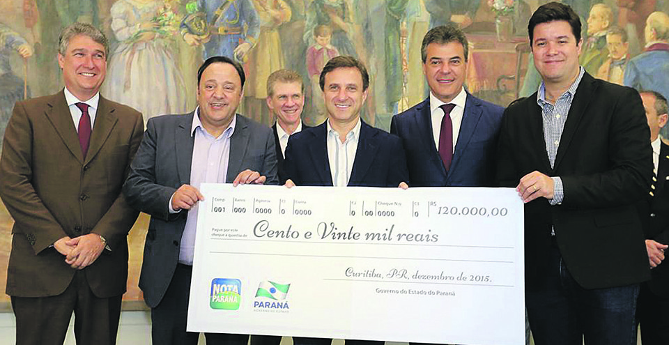 Presidente do Grupo Positivo, Helio Rotenberg (de terno azul, no centro, ao lado de Beto Richa), com o cheque do prêmio de R$ 120 mil | Arnaldo Alves / ANPr