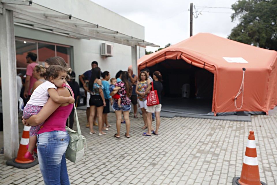 População espera atendimento em frente à  UPA de Paranaguá. O hospital de campanha, instalado na entrada da unidade, ainda não está funcionando. Cerca de 150 pessoas com sintomas de dengue têm procurado a UPA diariamente | Felipe Rosa/Gazeta do Povo