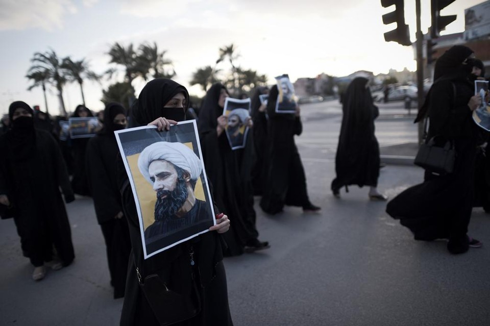 Manifestantes xiitas no Bahrein seguram a foto do líder religioso Nimr al-Nimr , morto na Arábia Saudita | MOHAMMED AL-SHAIKH/AFP