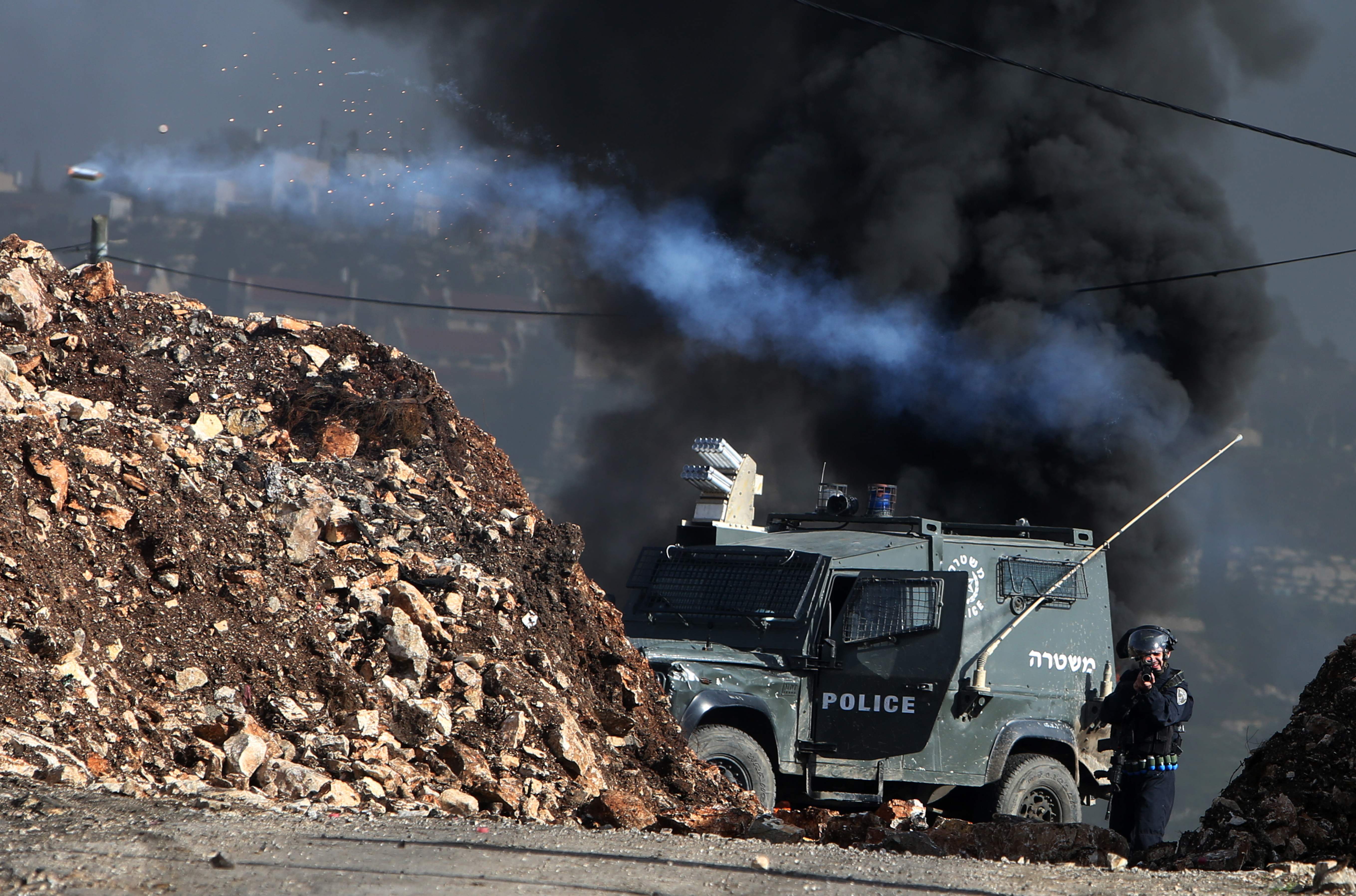Um militar israelense dispara gás lacrimogêneo em manifestantes palestinos durante confrontos | JAAFAR ASHTIYEH/AFP