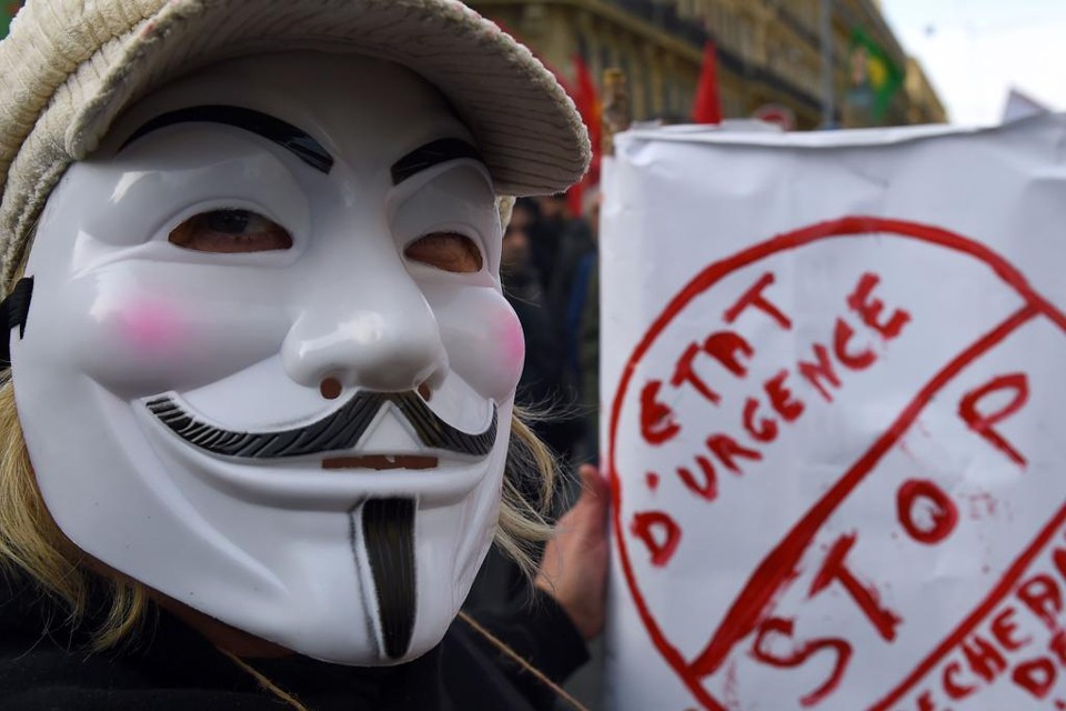 Usando máscara de Guy Fawkes, manifestante pede pelo fim do estado de emergência francês | BORIS HORVAT/AFP