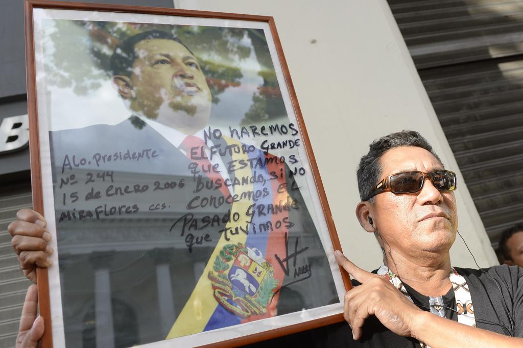 Apoiador de Maduro segura uma foto de Hugo Chavez, ex-líder venezuelano | FEDERICO PARRA/AFP