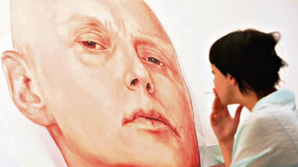 Visitante olha a pintura de Litvinenko em um hospital de Londres (imagem de arquivo). | NATALIA KOLESNIKOVA/AFP