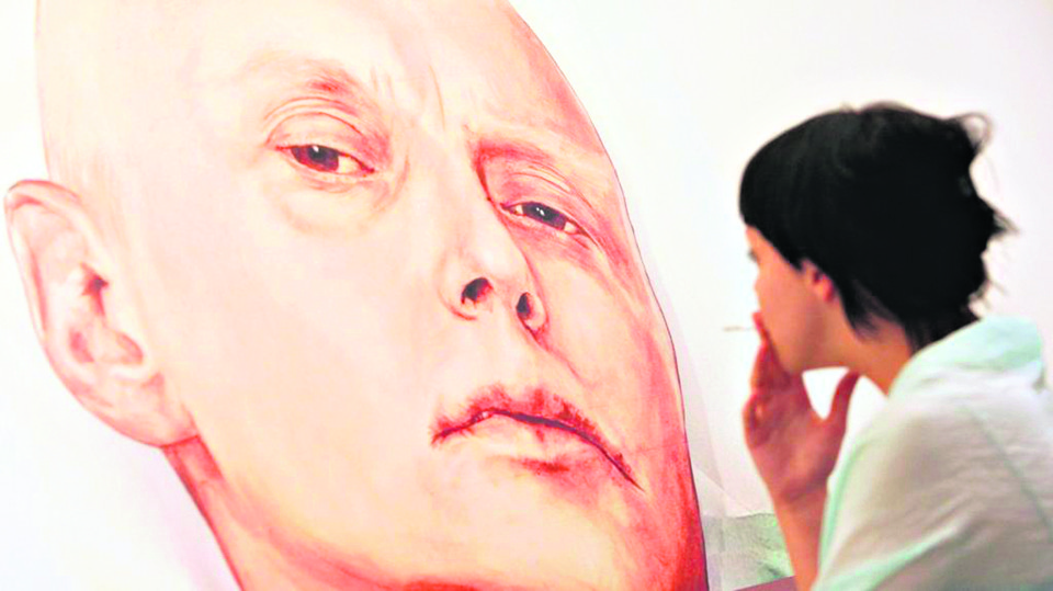 Putin “provavelmente” aprovou morte de ex-espião, diz investigação britânica Visitante olha a pintura de Litvinenko em um hospital de Londres (imagem de arquivo). | NATALIA KOLESNIKOVA/AFP