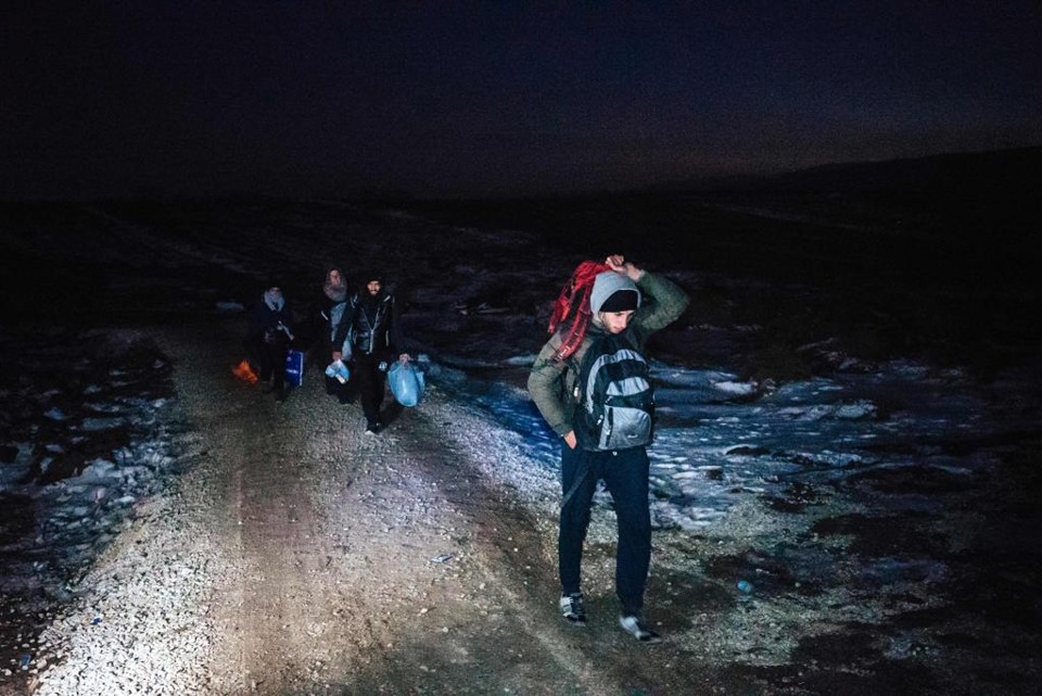 Migrantes caminham na fronteira entre Macedônia e Sérvia, sob o frio intenso do inverno europeu | DIMITAR DILKOFF/AFP
