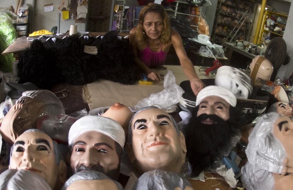 Funcionária arruma as máscaras para a venda: de Bin Laden a Japonês da Federal, várias opções. | Vanderlei Almeida/AFP