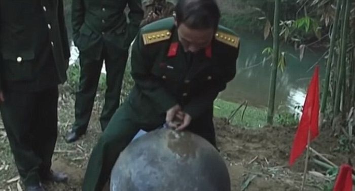 Oficial da Defesa vietnamita tenta erguer uma das esferas, que pesa 45 quilos | Divulgação/Defesa Vietnã