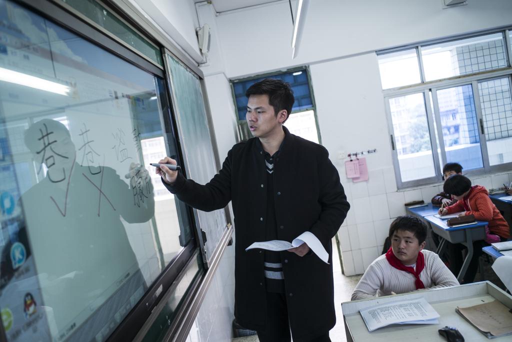 Lin Wei dá aula a alunos da sexta série em uma escola em Fuzhou, na China | LAM YIK FEI/NYT