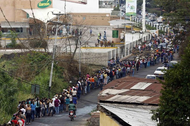 Pessoas formam fila, uma cena comum na Venezuela, para fazer as compras em um supermercado | JS/KR/Carlos Garcia Rawlins
