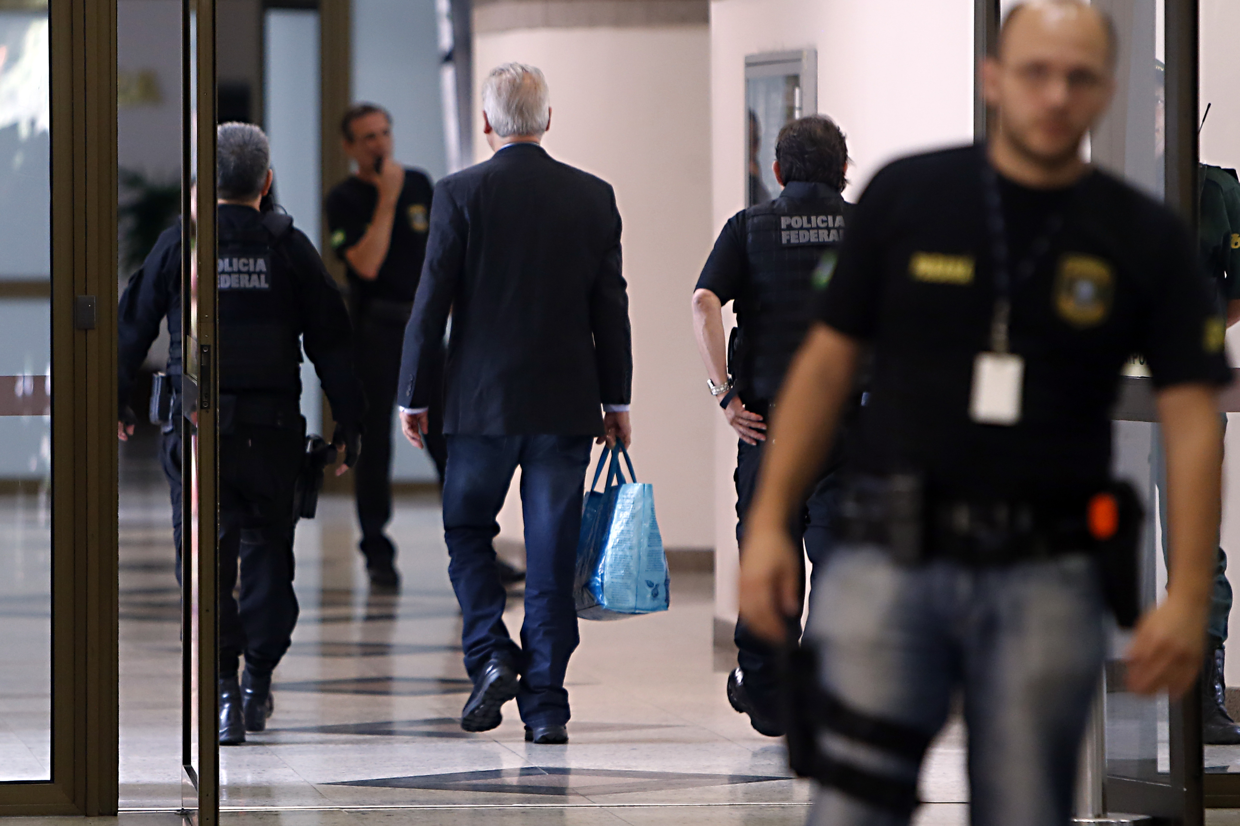 José Dirceu (com a sacola) azul chega para depor na sede da Justiça Federal: dificuldades financeiras. | Albari Rosa/Gazeta do Povo