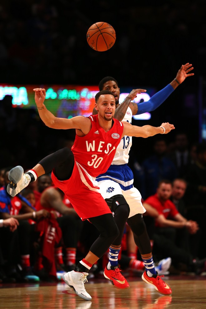 Stephen Curry briga pela bola com Paul George no All-Star Game | ELSA/AFP