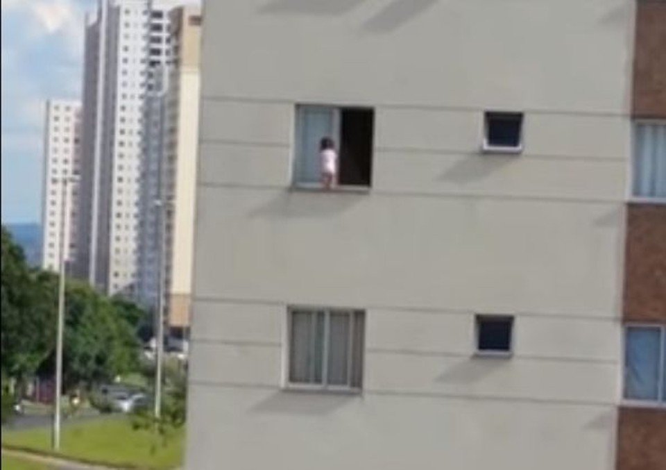 Vídeo feito por vizinho mostra o perigo de uma criança vagando entre a janela e a rede de proteção de um apartamento em Guará, no Distrito Federal | Reprodução/Youtube/