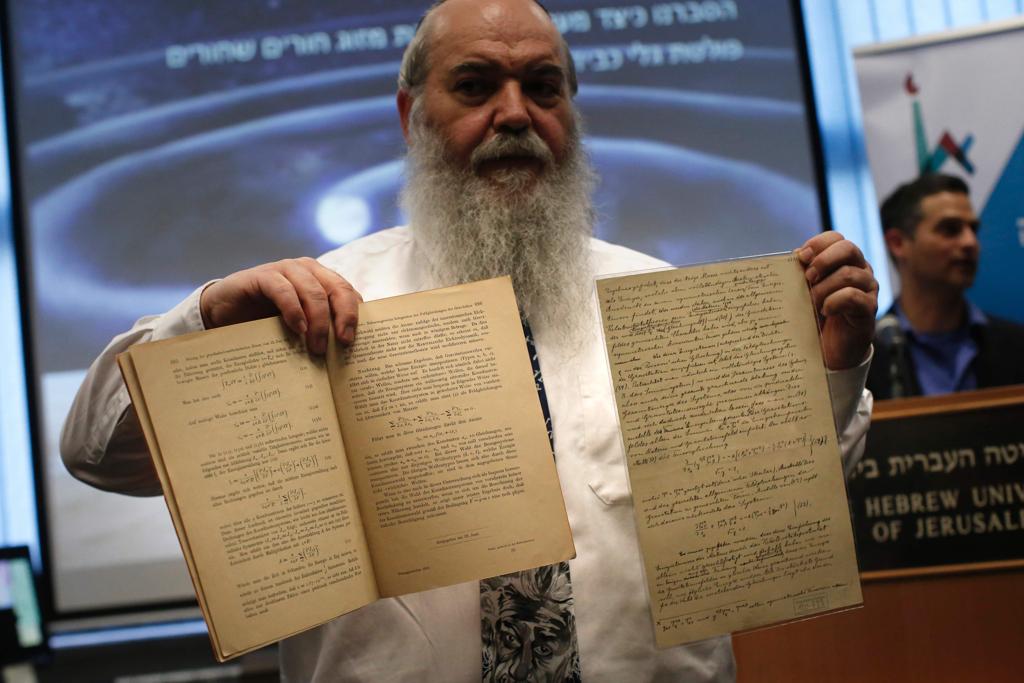 Roni Grosz, diretor dos Arquivos de Albert Eistein da Universidade Hebraica de Jerusalém, mostra os documentos originais do físico que apontavam para a existência das ondas gravitacionais | THOMAS COEX/AFP