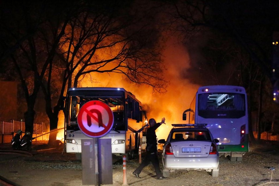 Policial sinaliza enquanto bombeiros tentam apagar as chamas causadas pela explosão | STRINGER/AFP