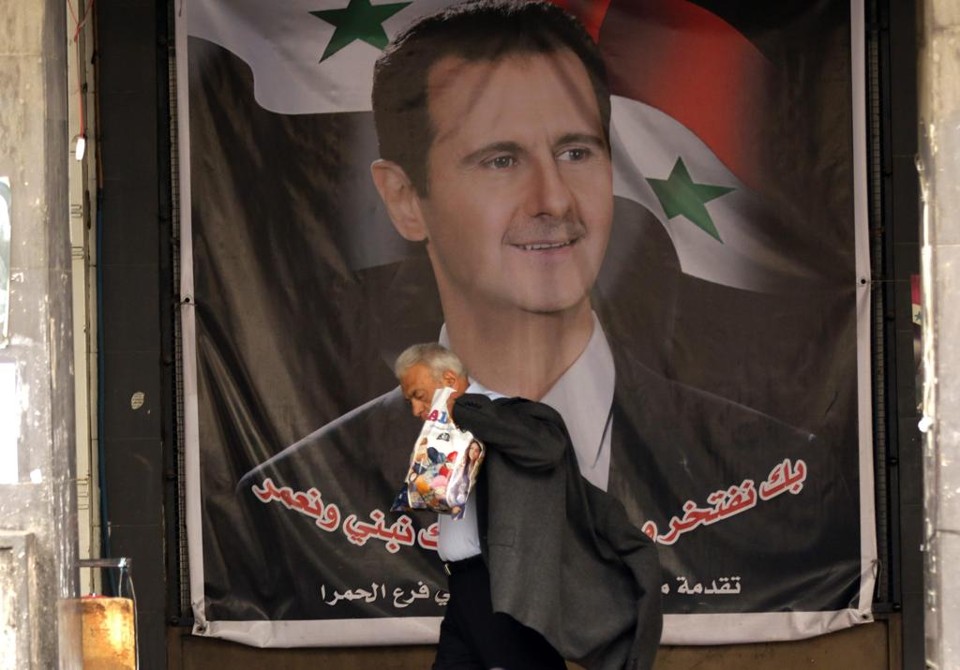 Pôster de Assad em uma rua de Damasco. Governo sírio anunciou que acatará cessar-fogo a partir de sábado (27) | LOUAI BESHARA/AFP