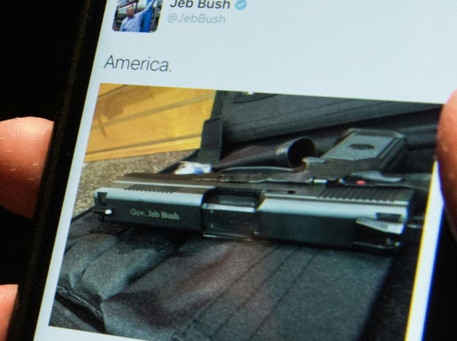 Homem olha postagem de Jeb Bush no Twitter: uma arma com a inscrição de seu nome | NICHOLAS KAMM/AFP