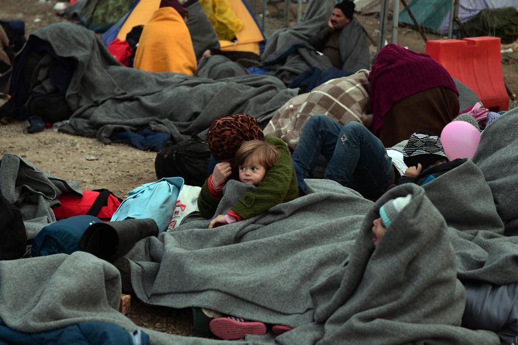 Refugiados em um campo de refugiados na fronteira da Macedônia com a Grécia | LOUISA GOULIAMAKI/AFP