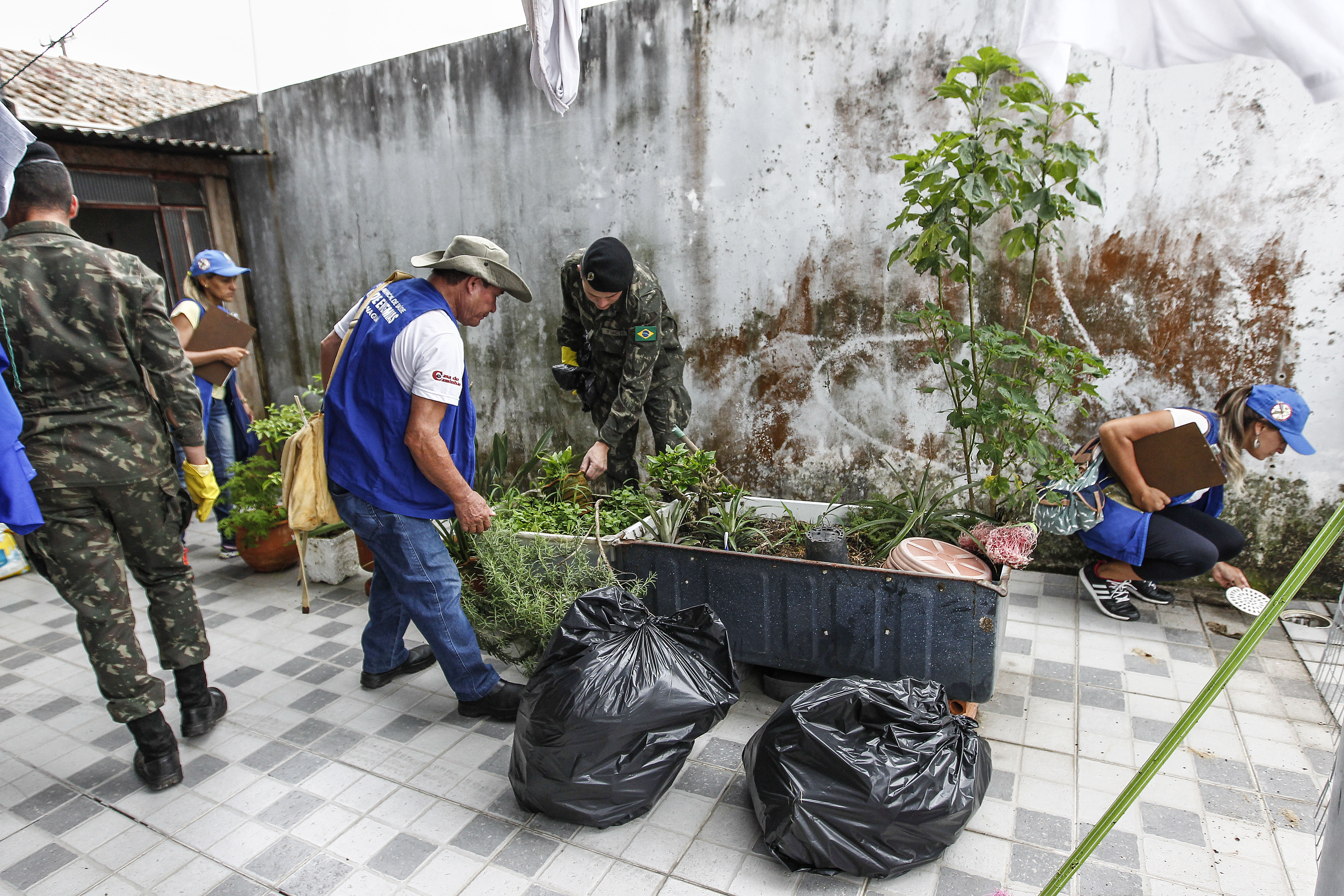 Agentes e soldados das Forças Armadas em inspeção a uma residência em Paranaguá, no Litoral do Paraná. Uso de larvicida é recomendado apenas em locais de difícil limpeza, como tanques e piscinas abandonadas. | Jonathan Campos/Gazeta do Povo