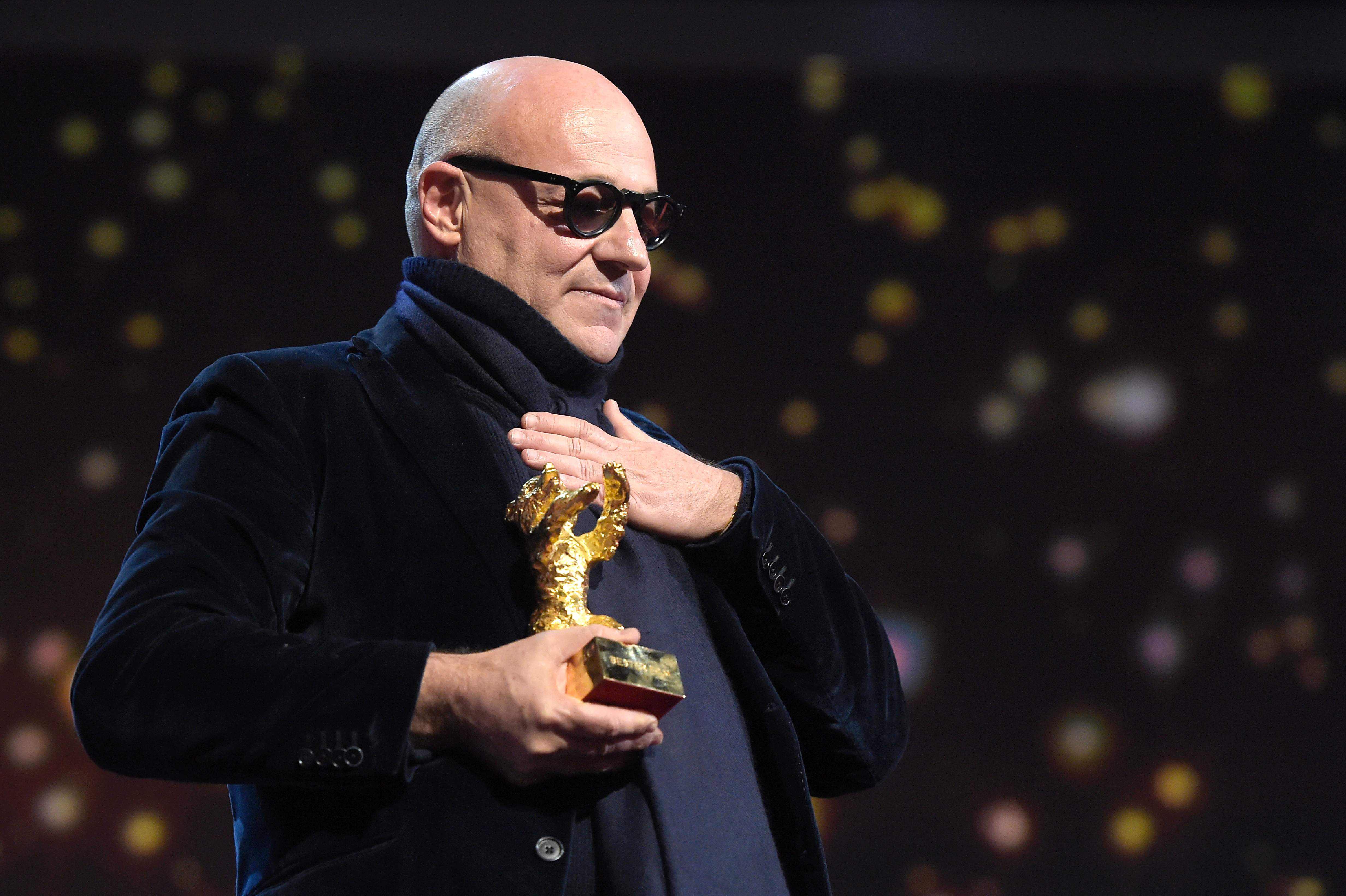 O italiano Gianfranco Rosi recebendo o Urso de Ouro durante a premiação do Festival de Berlim. | TOBIAS SCHWARZ/AFP