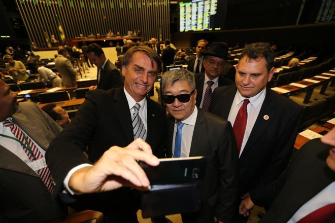 Jair Bolsonaro tira selfie com Newston Ishii, da Polícia Federal. | Alan Marques/Folhapress