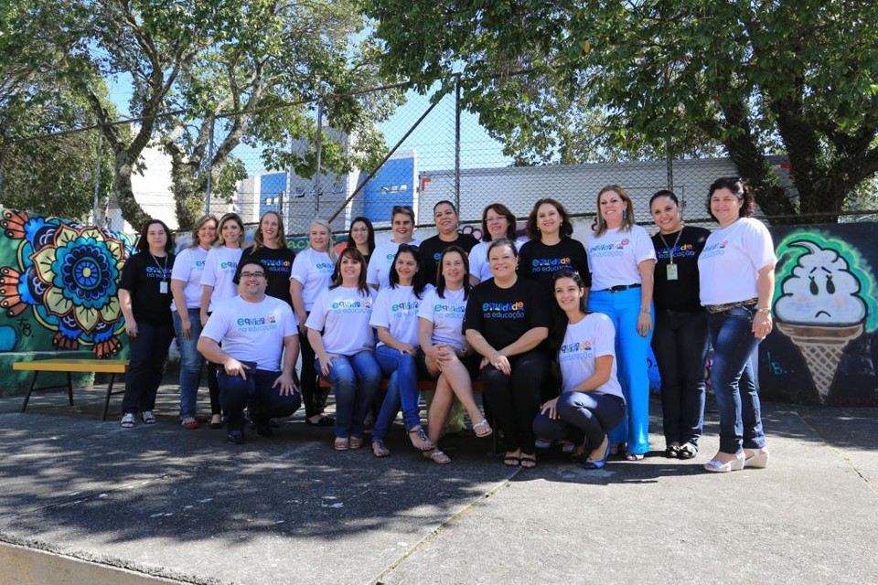 Parte dos técnicos diretamente ligados ao Projeto Equidade posam para fotos no pátio da Escola Municipal Omar Sabbag, no Cajuru: programa comemora um ano e festeja queda de evasão de alunos entre escolas assistidas. | Ivonaldo Alexandre/Gazeta do Povo
