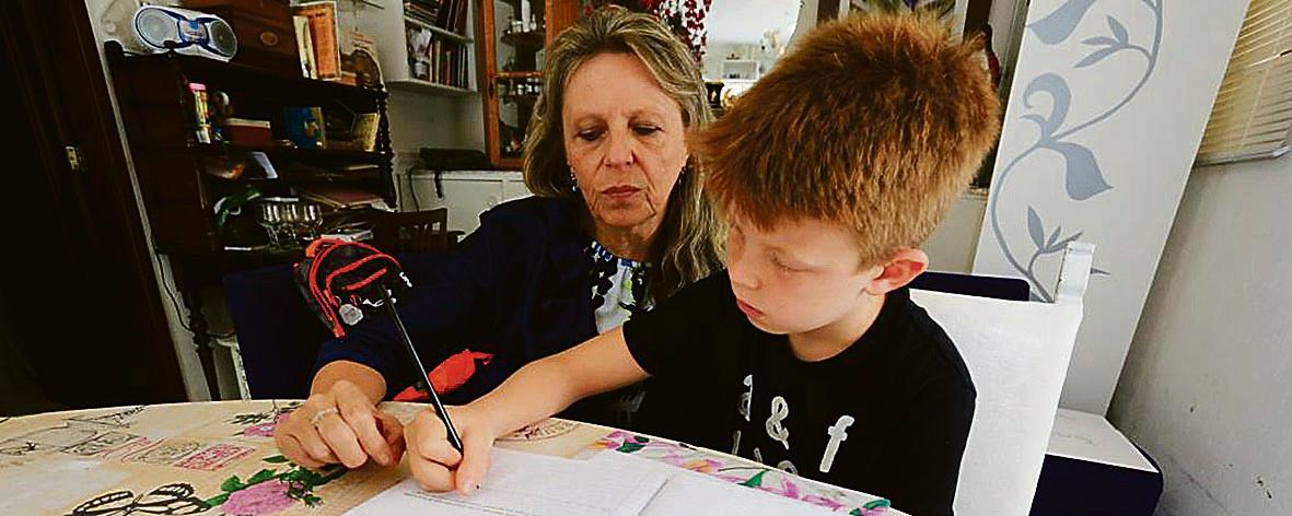 A especialista em grafologia Inês Gomes com Cauê, um dos estudantes que frequenta aulas de caligrafia: para ela, a letra cursiva melhora o desenvolvimento cognitivo e a autoestima | Ivonaldo Alexandre/Gazeta do Povo